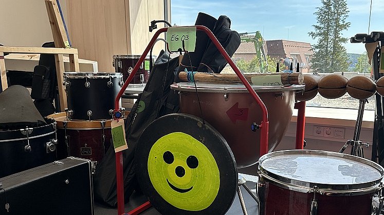 Ein Klassenzimmer mit verschiedenen Musikinstrumenten wie Schlagzeug, Keyboard, Pauke. 